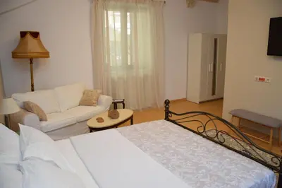 a bedroom with a bed and a living room with a couch at Chania 1548 Old Town Apartments in Chania Town