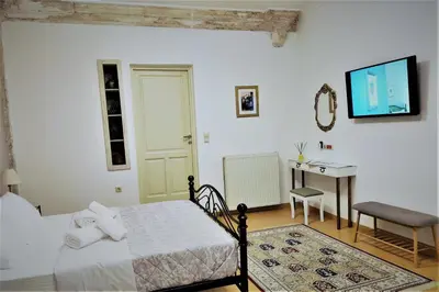 a bedroom with a bed and a table and a desk at Chania 1548 Old Town Apartments in Chania Town