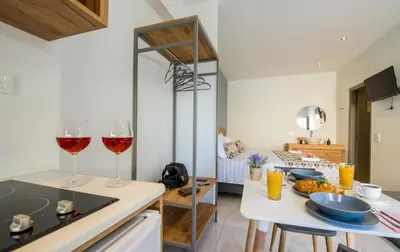 a kitchen with two glasses of wine on a counter at Linda Apartments Platanias in Plataniás