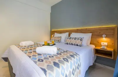 a bedroom with a large bed with two drinks on it at Linda Apartments Platanias in Plataniás