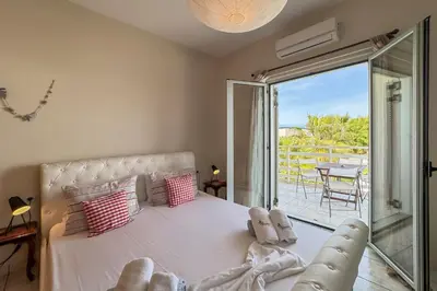 a bedroom with a large bed and a balcony at Alisahni Home 2 in Daratso