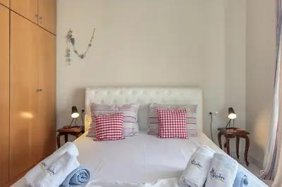 a bedroom with a white bed with red and white pillows at Alisahni Home 2 in Daratso