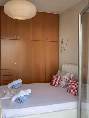 a bedroom with a bed with wooden cabinets and towels at Alisahni Home 2 in Daratso