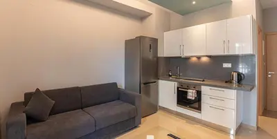 a living room with a couch and a kitchen at On the sand 2 in Palaiochóra