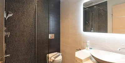 a bathroom with a sink and a toilet and a mirror at On the sand 2 in Palaiochóra