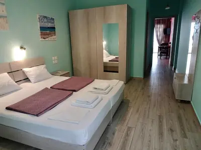a bedroom with a bed with white sheets and a mirror at Faros apartment in Sfakiá