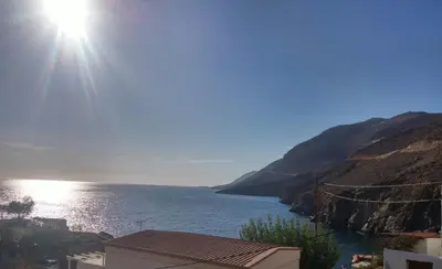 a view of a body of water with the sun at Faros apartment in Sfakiá