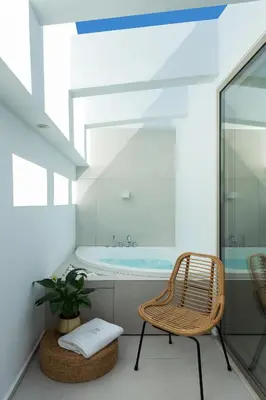 a bathroom with a chair and a tub at Mirabile Luxury Suites in Chania Town