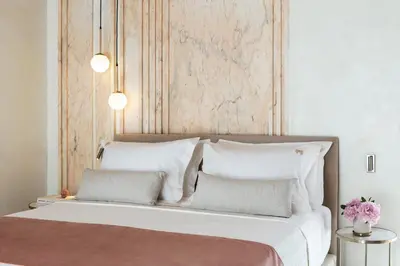 a bedroom with a large bed with white pillows at Mirabile Luxury Suites in Chania Town