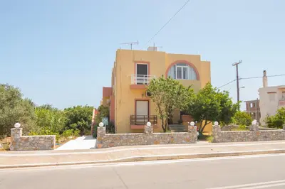 a yellow house on the side of a street at eden of grameno in Palaiochóra