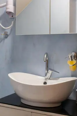 a white sink in a bathroom with a white cabinet at Charming Flatlet in the Old Town in Chania Town