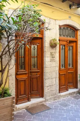 a pair of wooden doors on the side of a house at Charming Flatlet in the Old Town in Chania Town