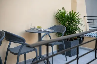 a table and chairs on a balcony with plants at Camere Maritima in Chania Town