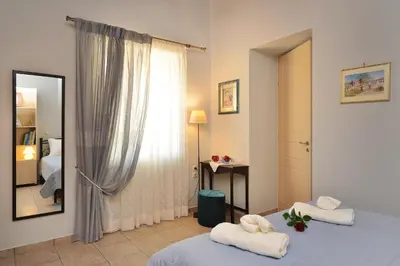 a bedroom with a mirror and a bed with towels at George's House between Falasarna and Balos in Kissamos