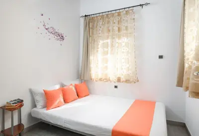 a bedroom with a bed with orange pillows and a window at Matzi House in Chania Town