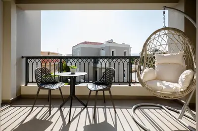 a balcony with two chairs and a table on a balcony at Limosa Luxury Residences in Kissamos