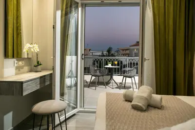 a bedroom with a bed and a balcony with a view at Limosa Luxury Residences in Kissamos