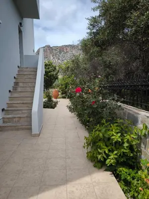 a walkway with flowers and a fence and stairs at Alexia Rooms in Palaiochóra
