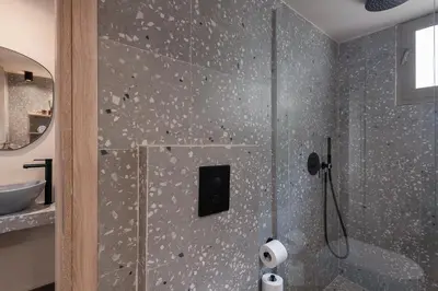 a bathroom with a shower with a glass door at Anaem Eclectic Rooms in Chania Town