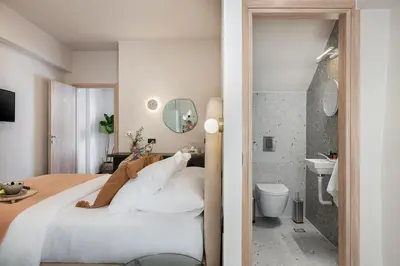 a bedroom with a white bed and a bathroom at Anaem Eclectic Rooms in Chania Town