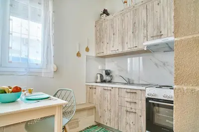 a kitchen with wooden cabinets and a table at Semeli Apartment in Kissamos