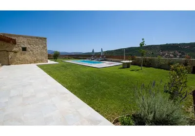 a garden with a swimming pool and a house at Villa Arietta in Kharkhalianá