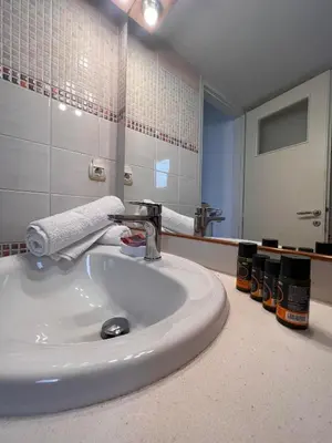 a bathroom with a white sink and a mirror at Vitro art House-in the heart of Chania in Chania Town