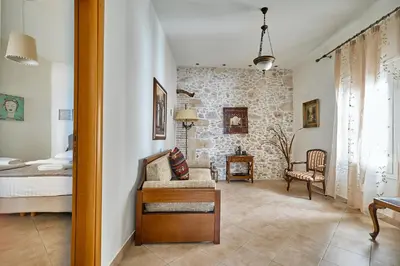 a bedroom with a bed and a living room at Ekavi Apartment in Kissamos