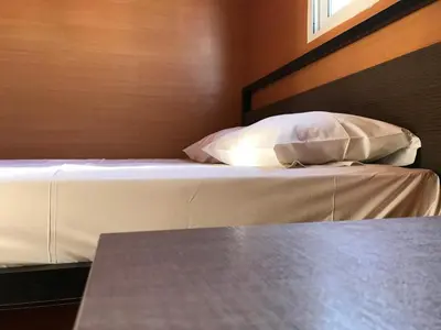 a bed with white sheets and pillows in a room at Elafonisi Rooms For Rent in Elafonisi