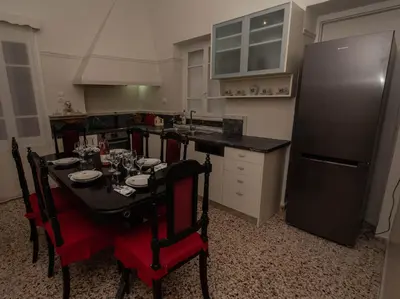 a kitchen with a table with chairs and a refrigerator at Reina House in Chania Town
