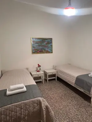 a bedroom with two beds and a painting on the wall at Reina House in Chania Town