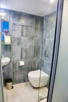 a bathroom with a toilet and a glass shower at Casa Anthos free parking in Chania Town