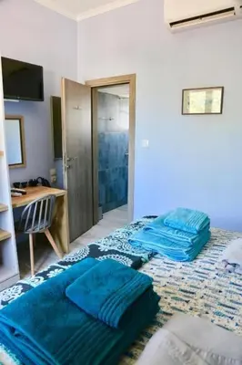a bedroom with two beds with blue sheets on it at Casa Anthos free parking in Chania Town