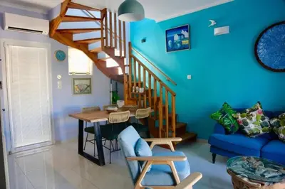 a blue living room with a wooden table and stairs at Casa Anthos free parking in Chania Town