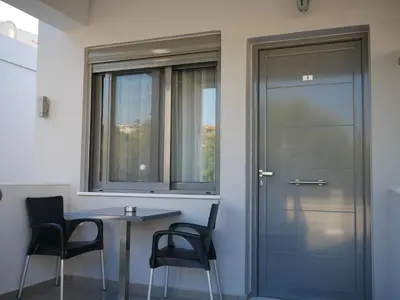 a room with a table and chairs and a door at Erotokritos Studios near the beach in Agia Marina Nea Kydonias