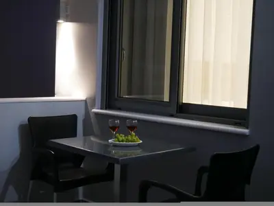 a table with two glasses of wine and a plate of fruit at Erotokritos Studios near the beach in Agia Marina Nea Kydonias