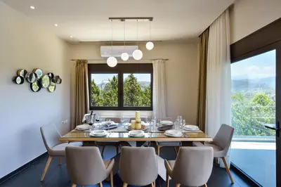 a dining room with a table and chairs and a large window at Villa Abelizia in Chania Town