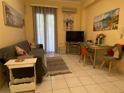 a living room with a couch and a table at The Green Apartment, 1 min walk from Kalamaki beach in Kalamaki Chanion