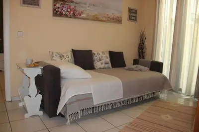 a bedroom with a bed with a table and a couch at The Green Apartment, 1 min walk from Kalamaki beach in Kalamaki Chanion