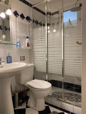a bathroom with a toilet and a shower and a sink at The Green Apartment, 1 min walk from Kalamaki beach in Kalamaki Chanion