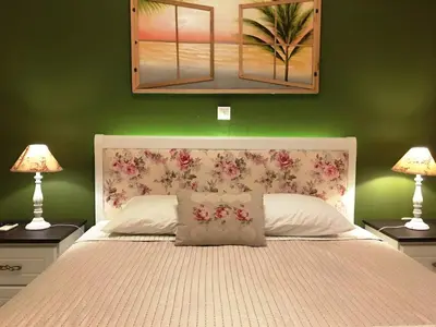 a bedroom with a large bed with two lamps at The Green Apartment, 1 min walk from Kalamaki beach in Kalamaki Chanion