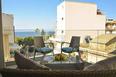 a balcony with chairs and a bowl of fruit on a table at Filia Luxury Apartments in Chania Town