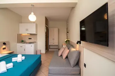 a living room with a couch and a flat screen tv at Libyan Sunrise in Palaiochóra