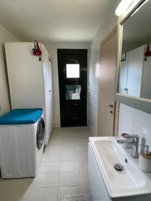 a bathroom with a washing machine and a sink at Maria`s Peaceful Nest in Chania Town