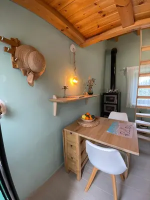 a kitchen with a wooden table and a white chair at Maria`s Peaceful Nest in Chania Town