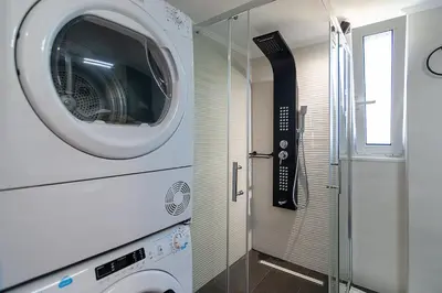 a washer and dryer in a bathroom with a window at Bitsakis Family II - Paleochora Luxury House in Palaiochóra
