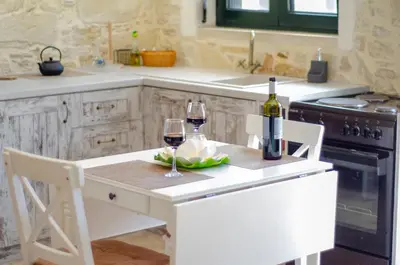 a kitchen with a table with two glasses of wine at La casa de Ioanna in Kissamos