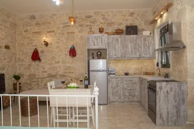 a kitchen with a white refrigerator and a table at La casa de Ioanna in Kissamos