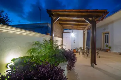 a patio with a wooden pergola and a table at La casa de Ioanna in Kissamos