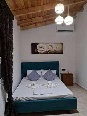 a bedroom with a bed with a blue headboard at La casa de Ioanna in Kissamos
